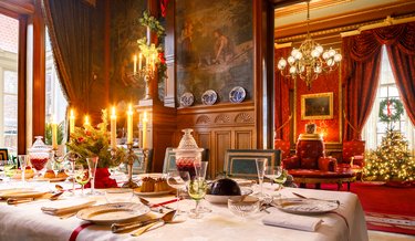 Feestelijk kerstdiner in de eetkamer en kerstbomen in de salon